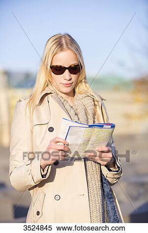 Stock Photography - Pretty touritst woman with map searching for direction with sunglasses. Fotosearch