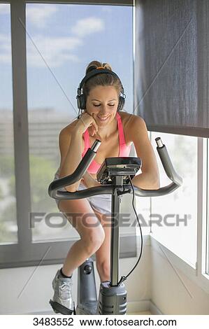 Pretty woman doing spinning bike in fitness center View Large Photo Image Stock Image - Pretty woman doing spinning bike in fitness center. Fotosearch