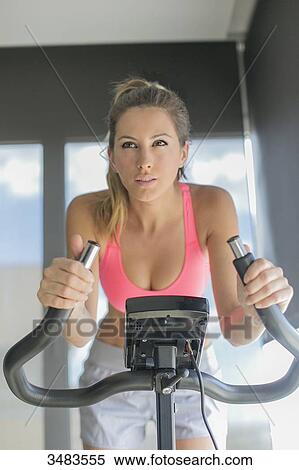 Pretty woman doing spinning bike in fitness center View Large Photo Image Stock Photography - Pretty woman doing spinning bike in fitness center. Fotosearch