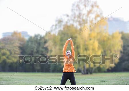 Pretty young woman stretching in park View Large Photo Image Stock Image - Pretty young woman stretching in park. Fotosearch