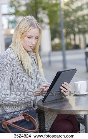 Pretty young woman with tablet in a Cafe in city center View Large Photo Image Picture - Pretty young woman with tablet in a Cafe in city center. Fotosearch
