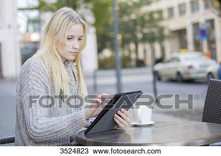 Pretty young woman with tablet in a Cafe in city center View Large Photo Image Stock Image - Pretty young woman with tablet in a Cafe in city center. Fotosearch
