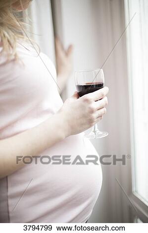 Profil closeup of a pregnant woman 6-month holding a glass of red wine. View Large Photo Image Stock Photo - Profil closeup of a pregnant woman 6-month holding a glass of red wine.. Fotosearch