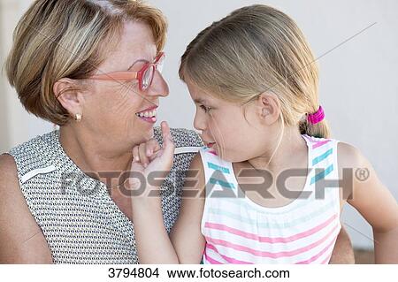 Profil portrait of a little girl in the lap of her grandmother. View Large Photo Image Picture - Profil portrait of a little girl in the lap of her grandmother.. Fotosearch