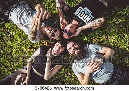 Selfie of a group of young Hipster lying in the grass View Large Photo Image Stock Photography - Selfie of a group of young Hipster lying in the grass. Fotosearch