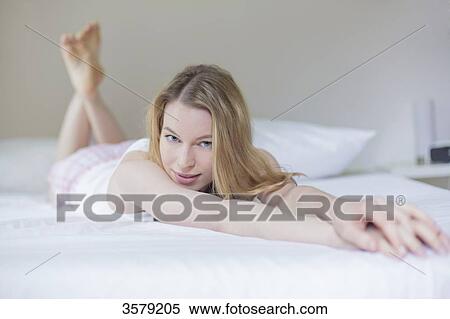 Sexy blonde woman lying in bed smiling at camera View Large Photo Image Stock Photography - Sexy blonde woman lying in bed smiling at camera. Fotosearch