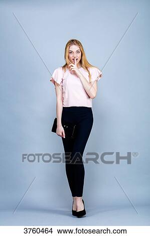 Smiling young woman in the foot, finger in mouth, looking toward the lens View Large Photo Image Picture - Smiling young woman in the foot, finger in mouth, looking toward the lens. Fotosearch