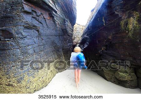 Spain, Galicia. Ribadeo. Moving shape between two large rocks. Las Catedrales beach. View Large Photo Image Stock Photography - Spain, Galicia. Ribadeo. Moving shape between two large rocks. Las Catedrales beach.. Fotosearch