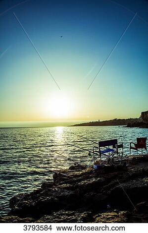 Sunset, fishing rods on the rocks, near Boca do Inferno (Hells Mouth), Cascais, Lisbon area, Portugal View Large Photo Image Picture - Sunset, fishing rods on the rocks, near Boca do Inferno (Hells Mouth), Cascais, Lisbon area, Portugal. Fotosearch