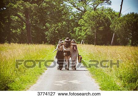 Three young Hipster back, walking on the country road View Large Photo Image Stock Photo - Three young Hipster back, walking on the country road. Fotosearch