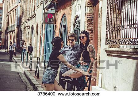 Three young people chatting in the street, cityscape View Large Photo Image Stock Image - Three young people chatting in the street, cityscape. Fotosearch