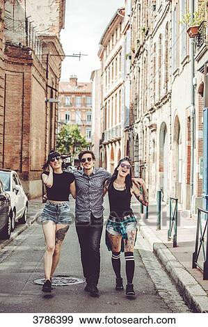 Three young people walking in the street, cityscape View Large Photo Image Stock Photo - Three young people walking in the street, cityscape. Fotosearch