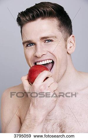topless man, biting an apple, looking at camera, smiling View Large Photo Image Stock Photo - topless man, biting an apple, looking at camera, smiling. Fotosearch