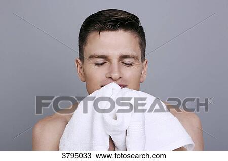 topless man, drying his chin with a towel after shaving, smiling, eyes closed, smelling a good smell View Large Photo Image Stock Image - topless man, drying his chin with a towel after shaving, smiling, eyes closed, smelling a good smell. Fotosearch