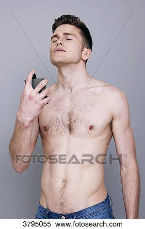 topless man, holding a bottle of perfume, spraying perfume on himself, eyes closed, wearing jeans, serious View Large Photo Image Stock Photography - topless man, holding a bottle of perfume, spraying perfume on himself, eyes closed, wearing jeans, serious. Fotosearch