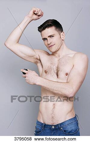 topless man, holding deodorant spray, arm up, spraying deodorant on his arm pit, looking at camera, wearing jeans, smiling View Large Photo Image Stock Photo - topless man, holding deodorant spray, arm up, spraying deodorant on his arm pit, looking at camera, wearing jeans, smiling. Fotosearch