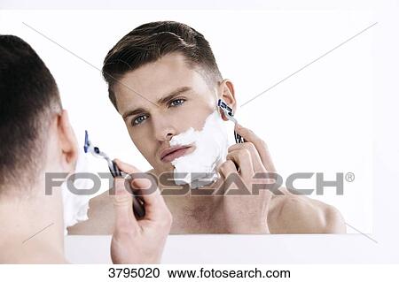 topless man, looking in the mirror, shaving, with shaver in his hand, shaving cream on half of his face View Large Photo Image Stock Image - topless man, looking in the mirror, shaving, with shaver in his hand, shaving cream on half of his face. Fotosearch