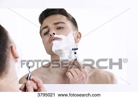 topless man, looking in the mirror, with shaving cream on his half of his face, with razor in his hands View Large Photo Image Stock Image - topless man, looking in the mirror, with shaving cream on his half of his face, with razor in his hands. Fotosearch