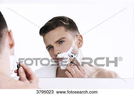 topless man, looking in the mirror, with shaving cream on his half of his face, with razor in his hands, shaving View Large Photo Image Stock Image - topless man, looking in the mirror, with shaving cream on his half of his face, with razor in his hands, shaving. Fotosearch