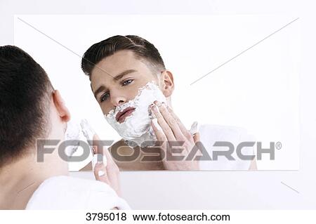 topless man, towel on his shoulder, looking in the mirror, applying shaving cream on his face View Large Photo Image Stock Photo - topless man, towel on his shoulder, looking in the mirror, applying shaving cream on his face. Fotosearch