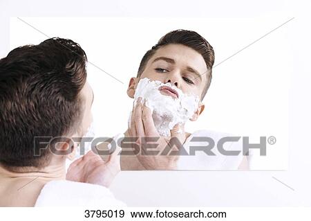 topless man, towel on his shoulder, looking in the mirror, applying shaving cream on his face View Large Photo Image Stock Photo - topless man, towel on his shoulder, looking in the mirror, applying shaving cream on his face. Fotosearch