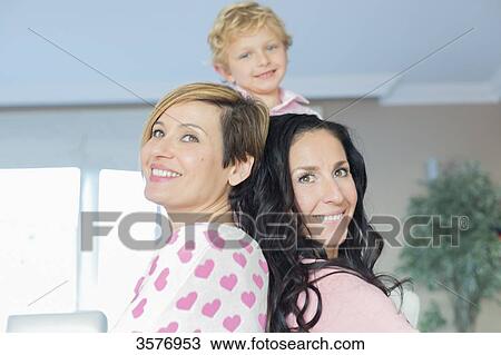 Stock Image - Two happy women and a cute little boy at home. Fotosearch