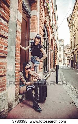 Stock Photo - Waiting two young women at the door of a building. Fotosearch