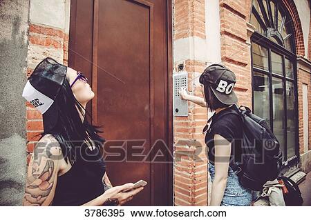 Waiting two young women at the door of a building View Large Photo Image Stock Photography - Waiting two young women at the door of a building. Fotosearch