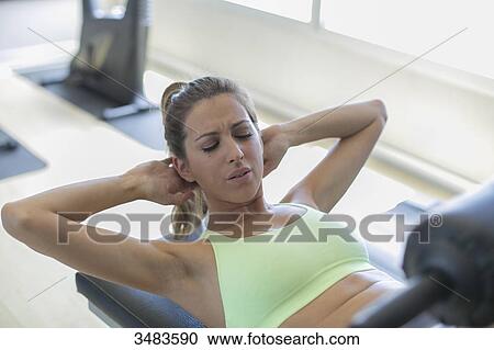 Woman doing crunches in fitness center View Large Photo Image Stock Image - Woman doing crunches in fitness center. Fotosearch