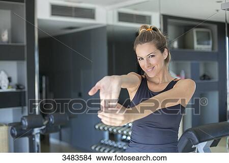Woman doing some stretching in fitness center View Large Photo Image Picture - Woman doing some stretching in fitness center. Fotosearch