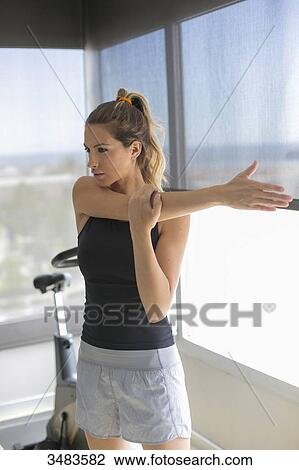 Woman doing some stretching in fitness center View Large Photo Image Stock Image - Woman doing some stretching in fitness center. Fotosearch