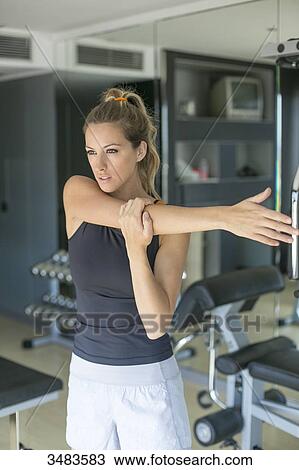 Woman doing some stretching in fitness center View Large Photo Image Stock Image - Woman doing some stretching in fitness center. Fotosearch