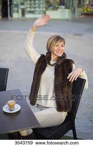 Stock Photo - Woman greeting in a Cafe outdoors. Fotosearch