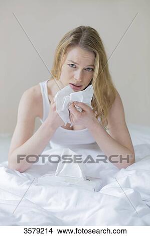 Woman sick with handkerschiefs in bed View Large Photo Image Picture - Woman sick with handkerschiefs in bed. Fotosearch