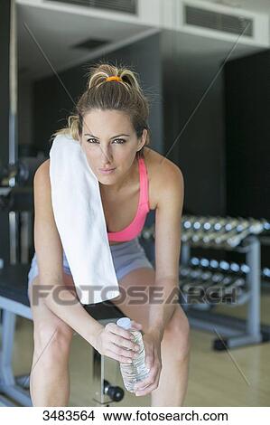 Picture - Woman taking a break in fitness center. Fotosearch