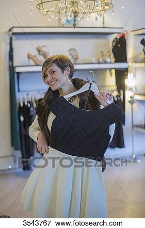 Woman trying on a dress in a clothes store View Large Photo Image Stock Photo - Woman trying on a dress in a clothes store. Fotosearch
