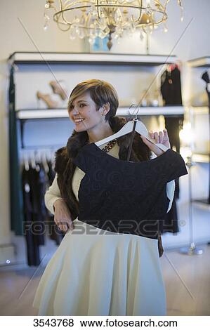 Woman trying on a dress in a clothes store View Large Photo Image Stock Photo - Woman trying on a dress in a clothes store. Fotosearch