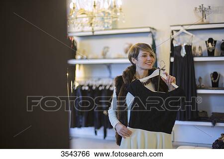 Woman trying on a dress in a clothes store View Large Photo Image Stock Photograph - Woman trying on a dress in a clothes store. Fotosearch