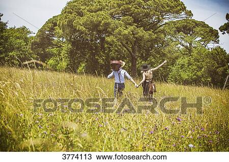 Young couple Hipster ride in the country, holding the hand over in a field View Large Photo Image Stock Image - Young couple Hipster ride in the country, holding the hand over in a field. Fotosearch