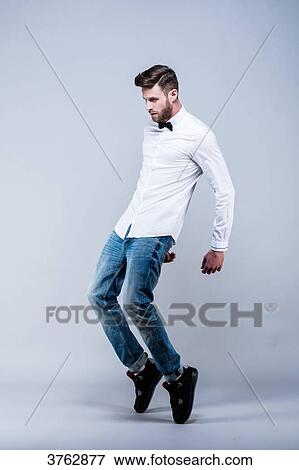 Young man in white shirt standing in profile, hands back, on tiptoe View Large Photo Image Stock Photo - Young man in white shirt standing in profile, hands back, on tiptoe. Fotosearch