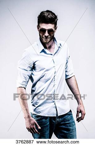 Stock Photo - Young man standing in shirt, face, arms along the body, the eye towards the goal. Fotosearch