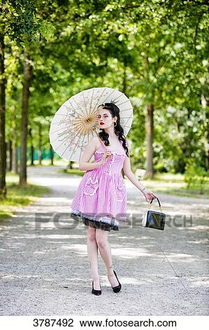 Young Pin Up Front, holding an umbrella and a handbag, looking at the camera View Large Photo Image Stock Image - Young Pin Up Front, holding an umbrella and a handbag, looking at the camera. Fotosearch
