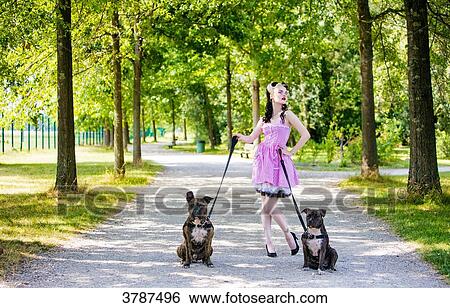Young Pin Up front, holding two dogs on leash View Large Photo Image Stock Photograph - Young Pin Up front, holding two dogs on leash. Fotosearch