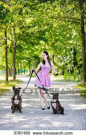 Young Pin Up front, holding two dogs on leash View Large Photo Image Stock Photography - Young Pin Up front, holding two dogs on leash. Fotosearch