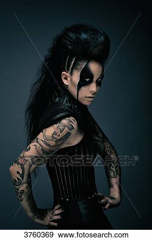 Young woman cyberpunk, tattooed, arms on hips, looking at the camera View Large Photo Image Stock Photo - Young woman cyberpunk, tattooed, arms on hips, looking at the camera. Fotosearch