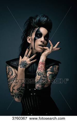 Young woman cyberpunk, tattooed, finger in mouth, looking at the camera View Large Photo Image Stock Photo - Young woman cyberpunk, tattooed, finger in mouth, looking at the camera. Fotosearch