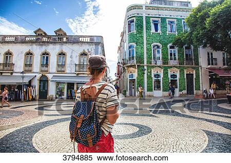Young woman from behind, observed the square of the town of Burgau, Algarve region, Portugal View Large Photo Image Stock Photography - Young woman from behind, observed the square of the town of Burgau, Algarve region, Portugal. Fotosearch
