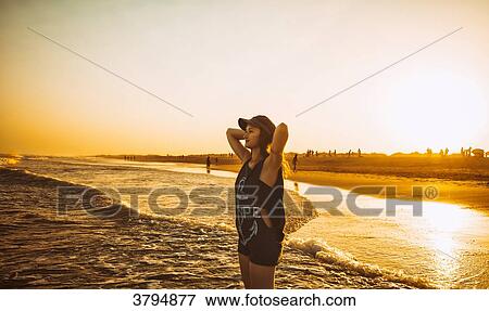 Young woman hands behind head, keep the sea on the beach Praia do Barril in a sunset, deTavira city, region of Algarve, Portugal View Large Photo Image Stock Photo - Young woman hands behind head, keep the sea on the beach Praia do Barril in a sunset, deTavira city, region of Algarve, Portugal. Fotosearch
