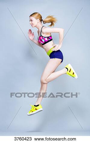 Young woman holding fitness, profile, courses and jumps on a gray background View Large Photo Image Stock Image - Young woman holding fitness, profile, courses and jumps on a gray background. Fotosearch