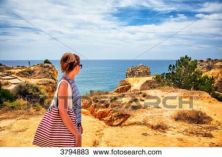 Young woman observing the sea from the cliffs of the cove of Praia de Galapinhos, Setubal, Lisbon area, Portugal View Large Photo Image Stock Image - Young woman observing the sea from the cliffs of the cove of Praia de Galapinhos, Setubal, Lisbon area, Portugal. Fotosearch